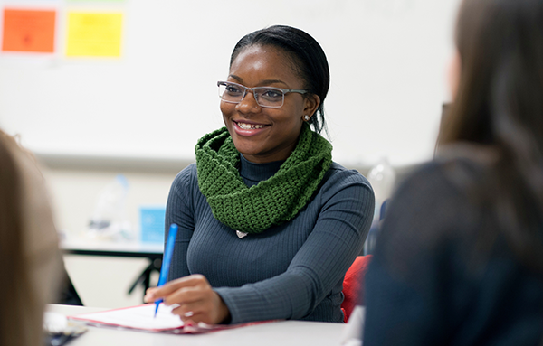 Image is of a woman sitting in a classroom